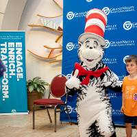 Young elementary school student poses with Cat in the Hat